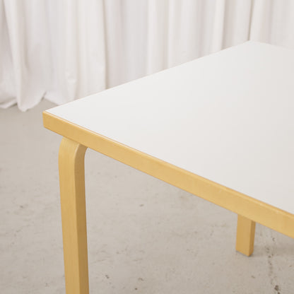 Artek drop-leaf table, white laminate surface and birch edge detail