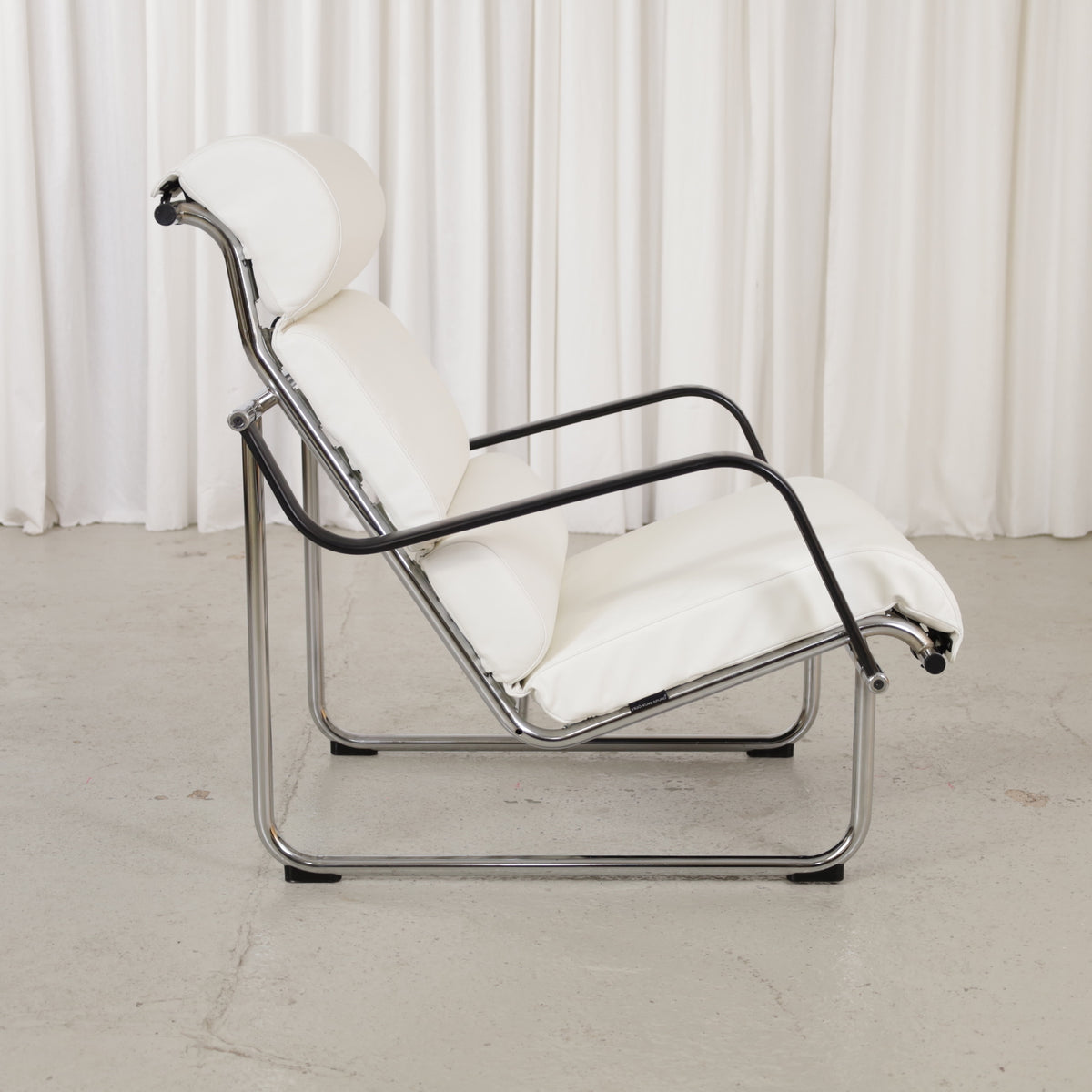 Side view of Remmi chair with chrome frame and black armrests
