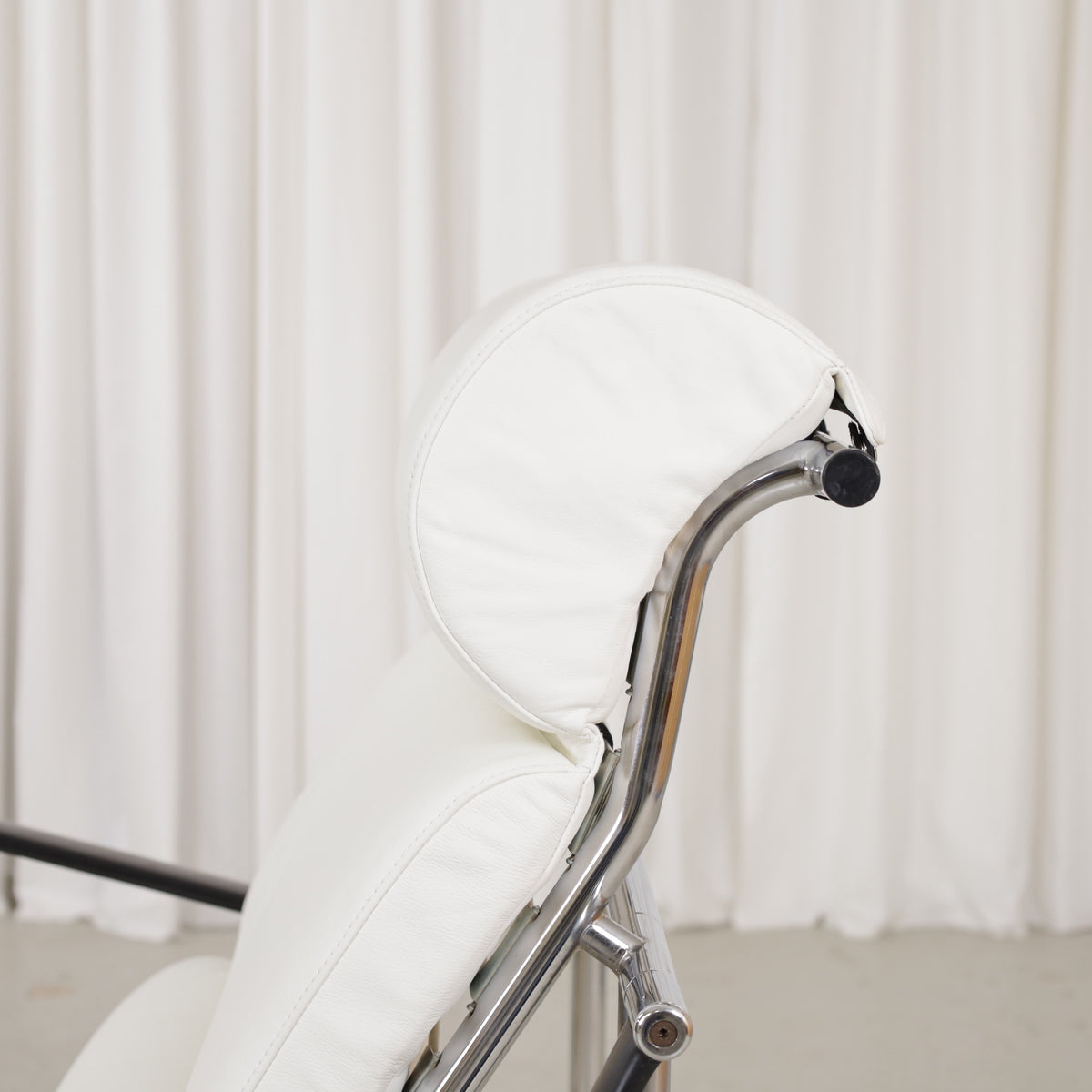 Detail of white leather head cushion and chrome frame