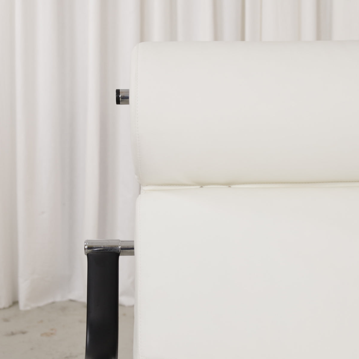 White leather cushion seams and chrome frame detail