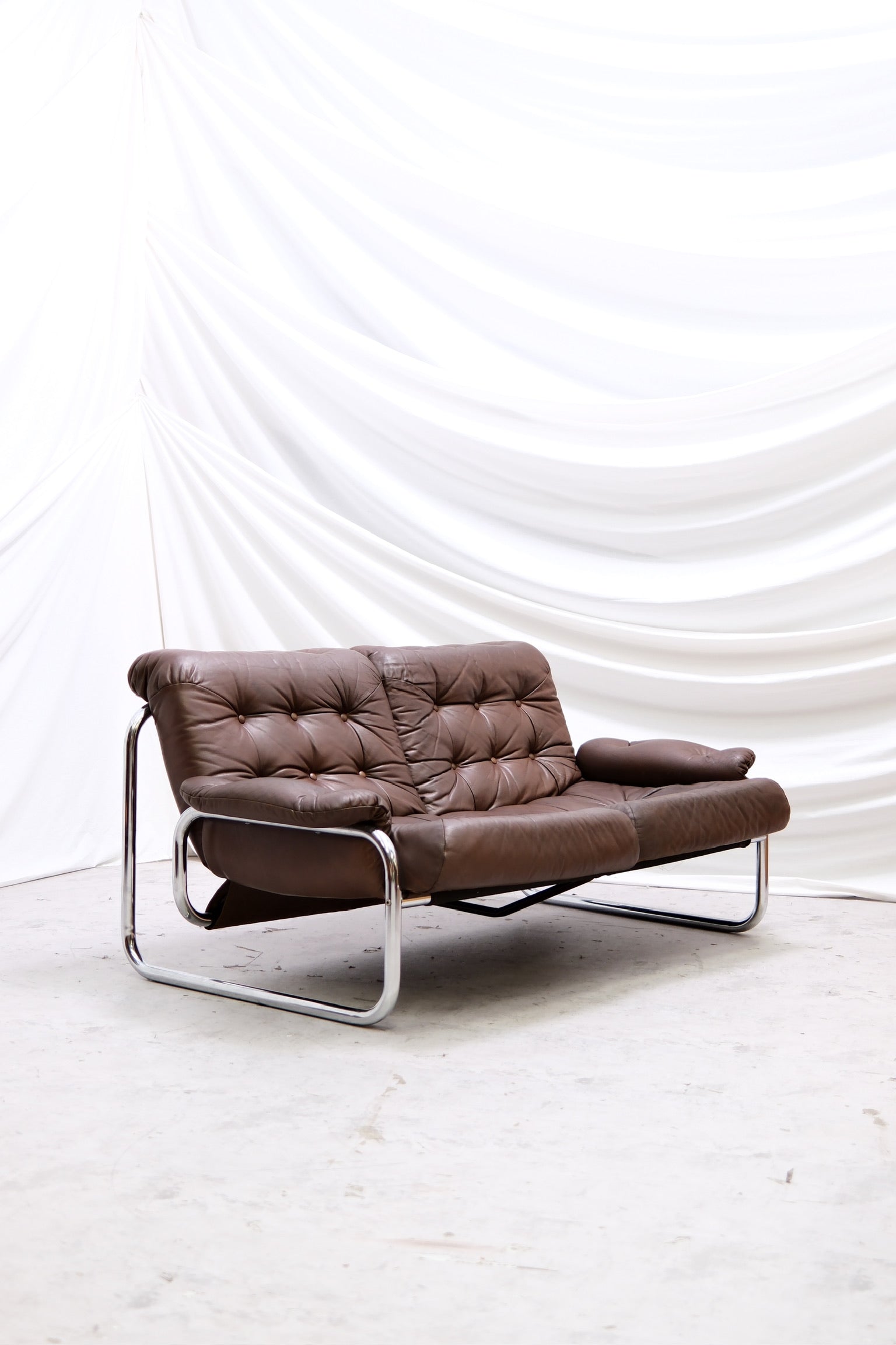 Vintage Ikea Borkum two seater sofa brown leather front view
Ikea Borkum vintage sofa side profile brown leather
Detail shot brown leather Ikea Borkum 2 seater
Back view Ikea Borkum vintage leather sofa