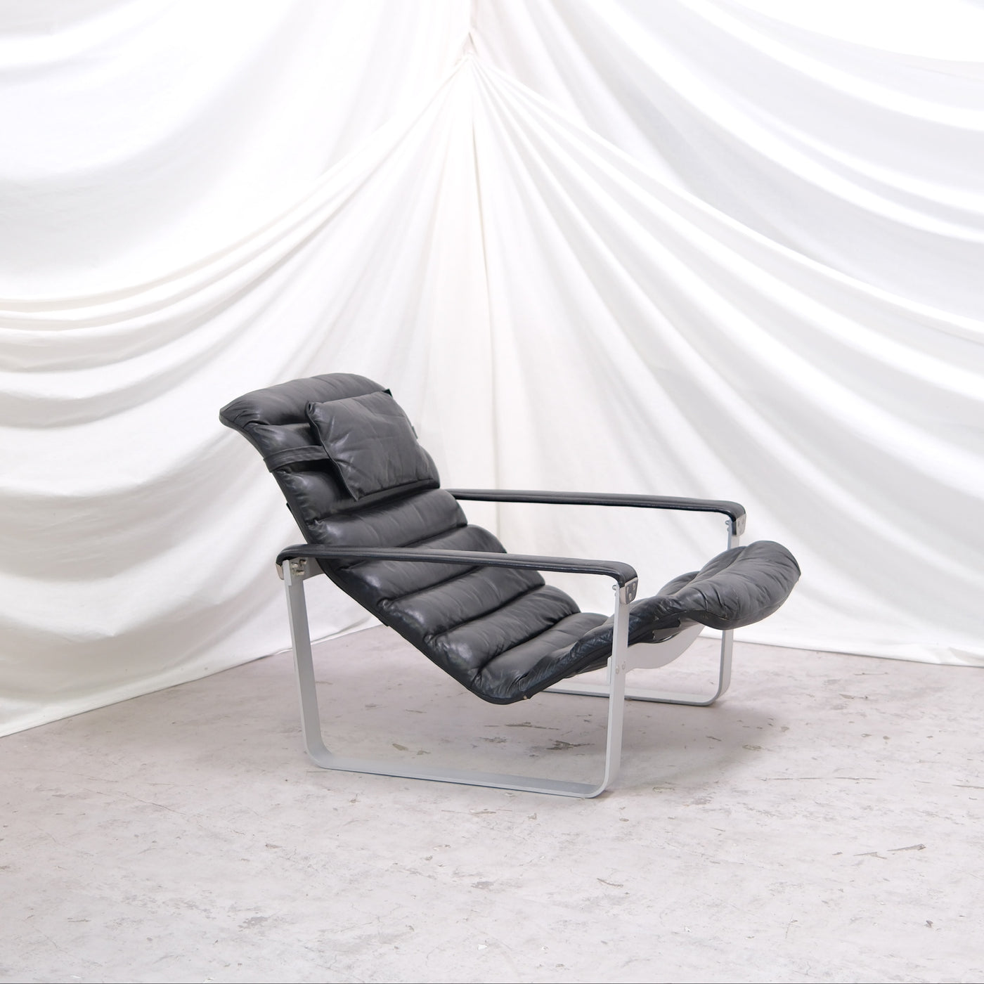 Ilmari Lappalainen Pulkka armchair by Asko Export. Black leather with aluminium frame and adjustable seat. Iconic Finnish lounge design. Worldwide shipping available.
