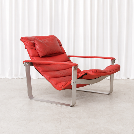 Vintage Pulkka lounge chair by Ilmari Lappalainen for Asko. Red leather upholstery and curved aluminium frame with attractive signs of age and use.