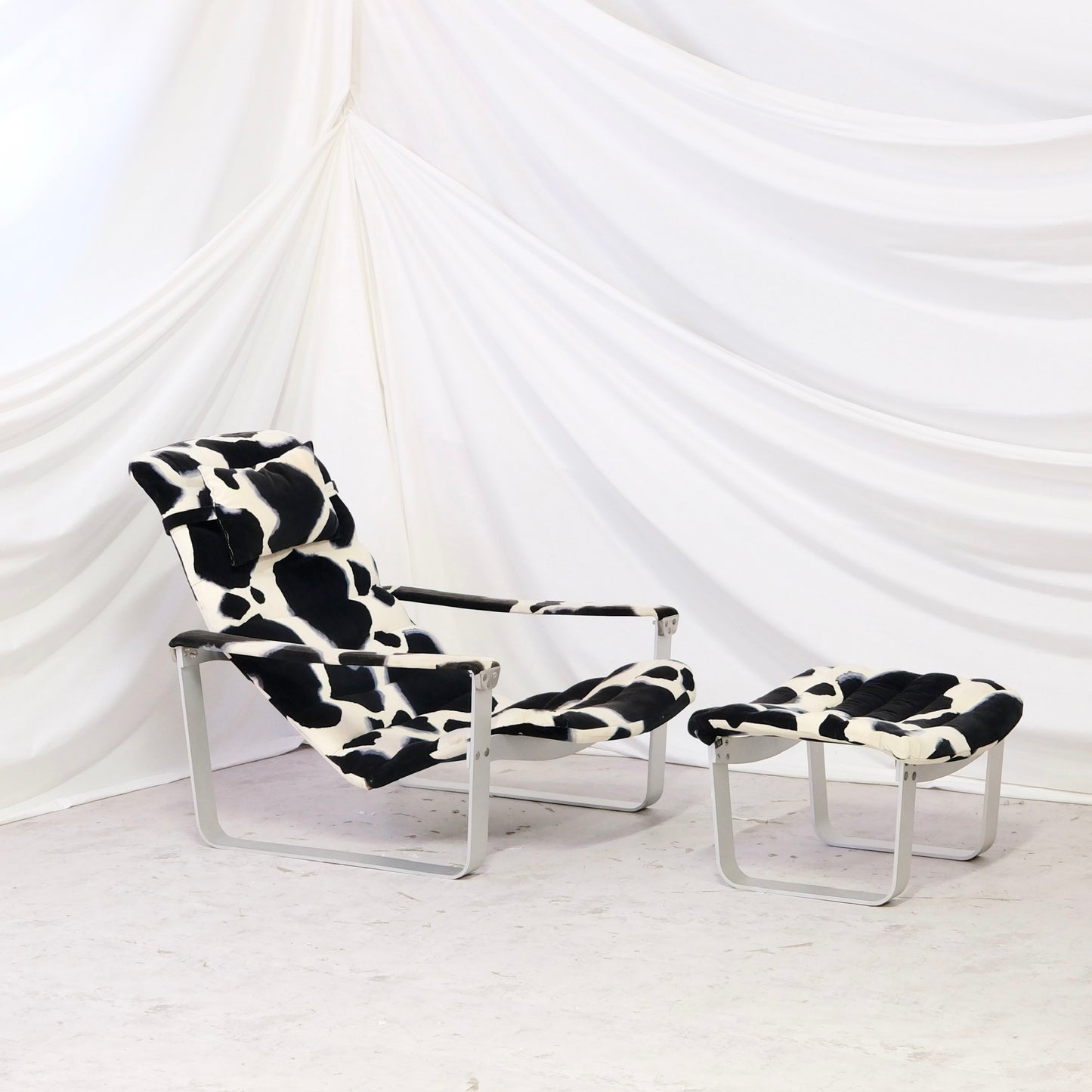 Vintage Ilmari Lappalainen Pulkka lounge chair with matching ottoman for Asko. Cowhide print canvas upholstery with white metal frame. Finnish design classic.