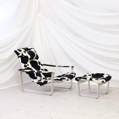 Vintage Ilmari Lappalainen Pulkka lounge chair with matching ottoman for Asko. Cowhide print canvas upholstery with white metal frame. Finnish design classic.