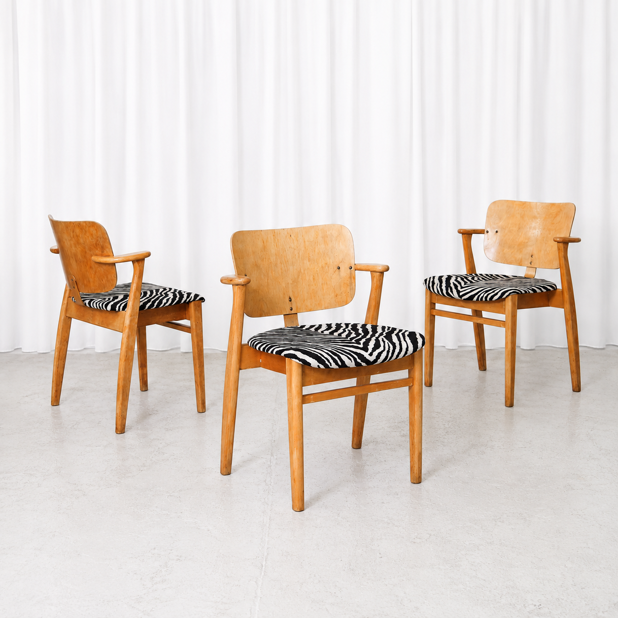 Vintage Domus chair by Ilmari Tapiovaara from the 1950s, featuring warm-toned wood and bold zebra upholstery. A Finnish design classic.