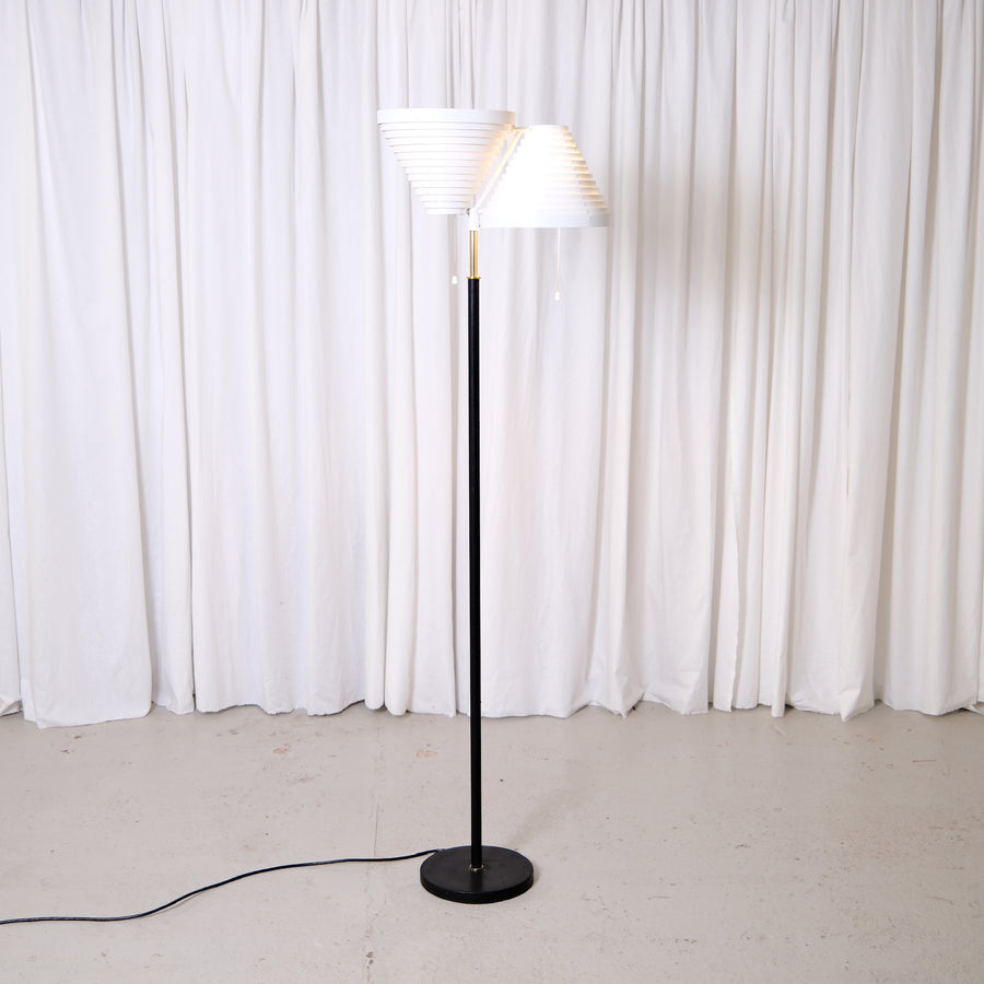 Rare Alvar Aalto A809 floor lamp manufactured by Valaisinpaja. Collectible Finnish modern lighting design with layered white metal shades and brass details.

