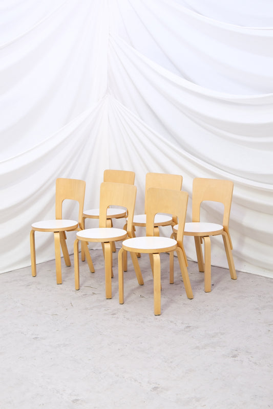 Set of six vintage Artek 66 chairs by Alvar Aalto with white laminate seats. Scandinavian dining classic with worldwide shipping.