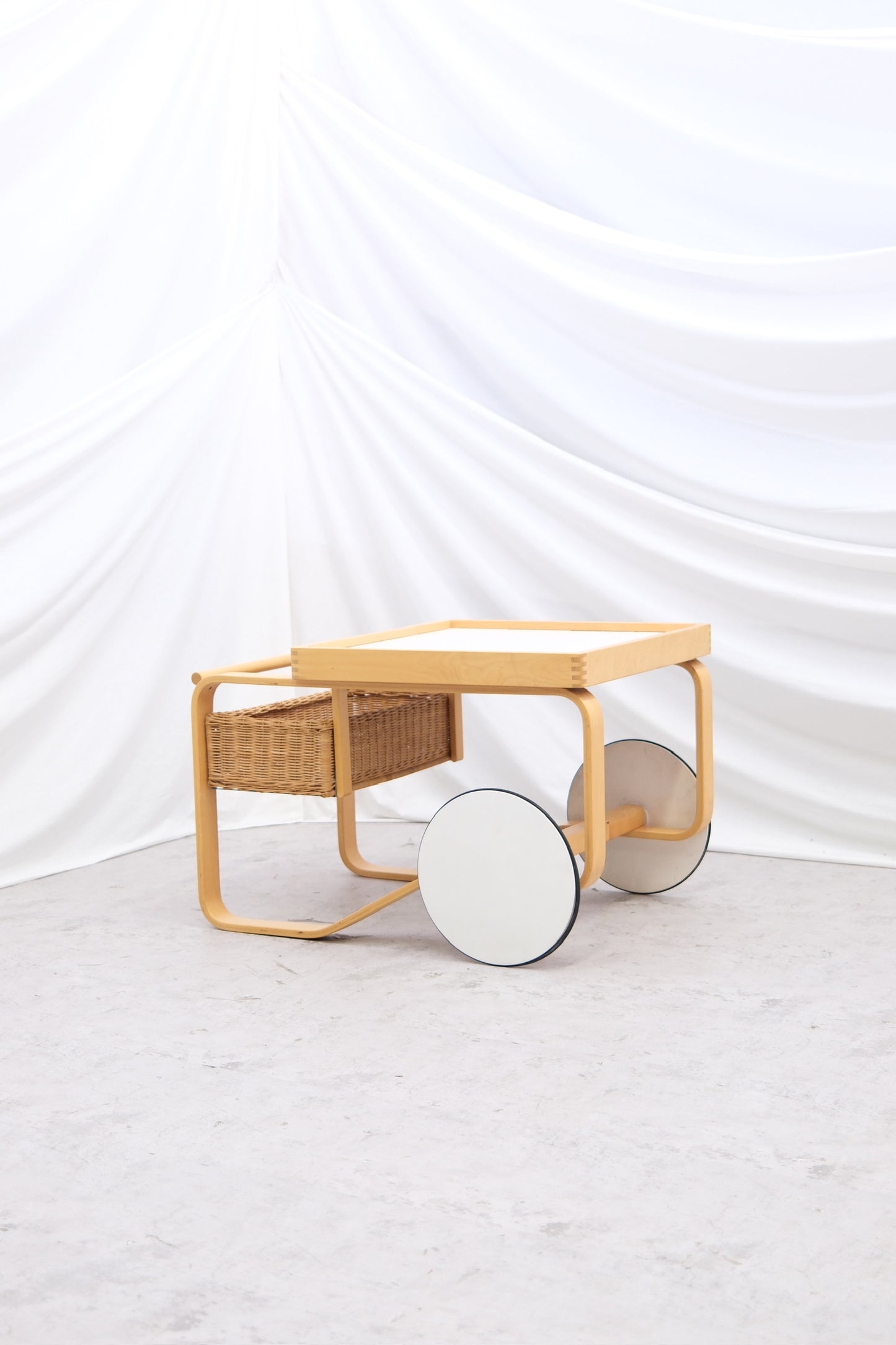 Original vintage Artek 900 serving trolley by Alvar Aalto with white tiled surface. Iconic Finnish utility design with worldwide shipping.
