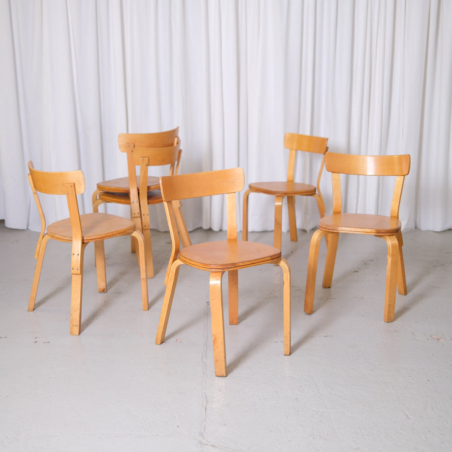 Set of vintage Alvar Aalto Chair 69 Sandwich chairs for Artek in natural birch with visible vintage patina photographed in studio.