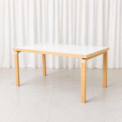 Vintage Artek 82A table designed by Alvar Aalto, featuring a white laminate top and bent birch legs. Very good condition. Measures 150 × 85 × 74 cm.