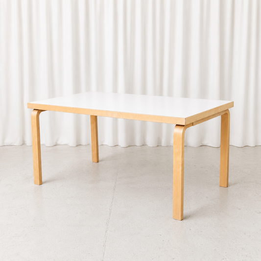 Vintage Artek 82A table designed by Alvar Aalto, featuring a white laminate top and bent birch legs. Very good condition. Measures 150 × 85 × 74 cm.