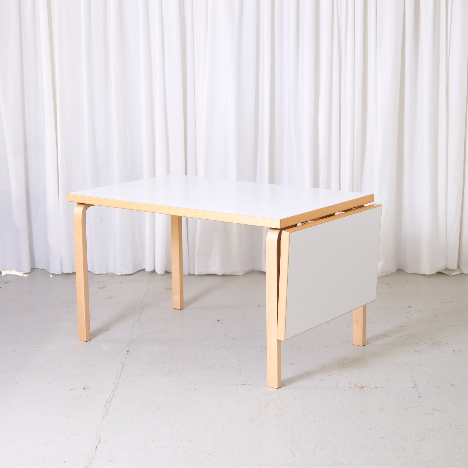 Vintage Artek Large Drop Leaf Table by Alvar Aalto with birch frame and white laminate top. Custom order Finnish design table with extension.