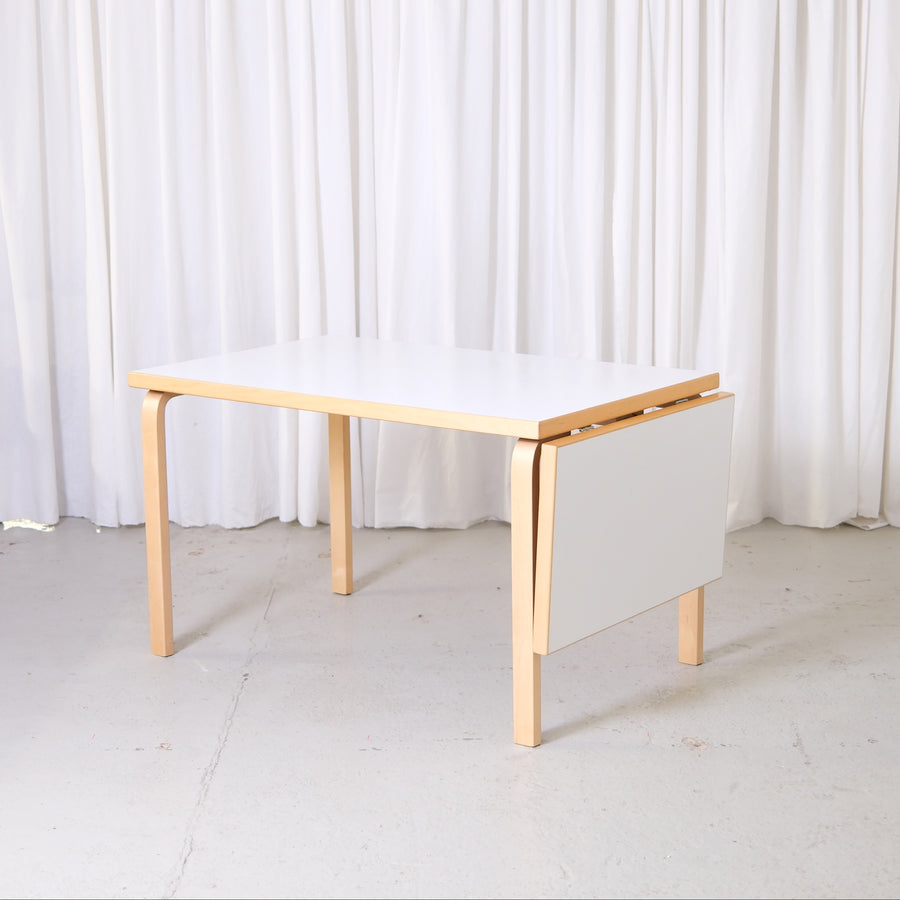 Vintage Artek Large Drop Leaf Table by Alvar Aalto with birch frame and white laminate top. Custom order Finnish design table with extension.