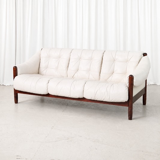 Vintage Brazilian style three-seater sofa with a stained beech frame and button-tufted white leather cushions. A sculptural and comfortable vintage piece.