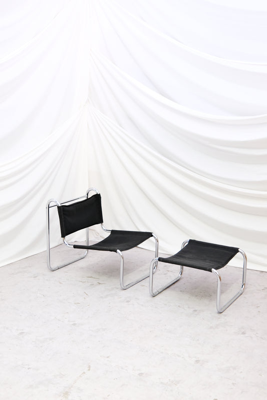 Vintage chrome lounge chair with matching ottoman. Tubular steel frame and black sling upholstery. Timeless modernist design. Worldwide shipping available.