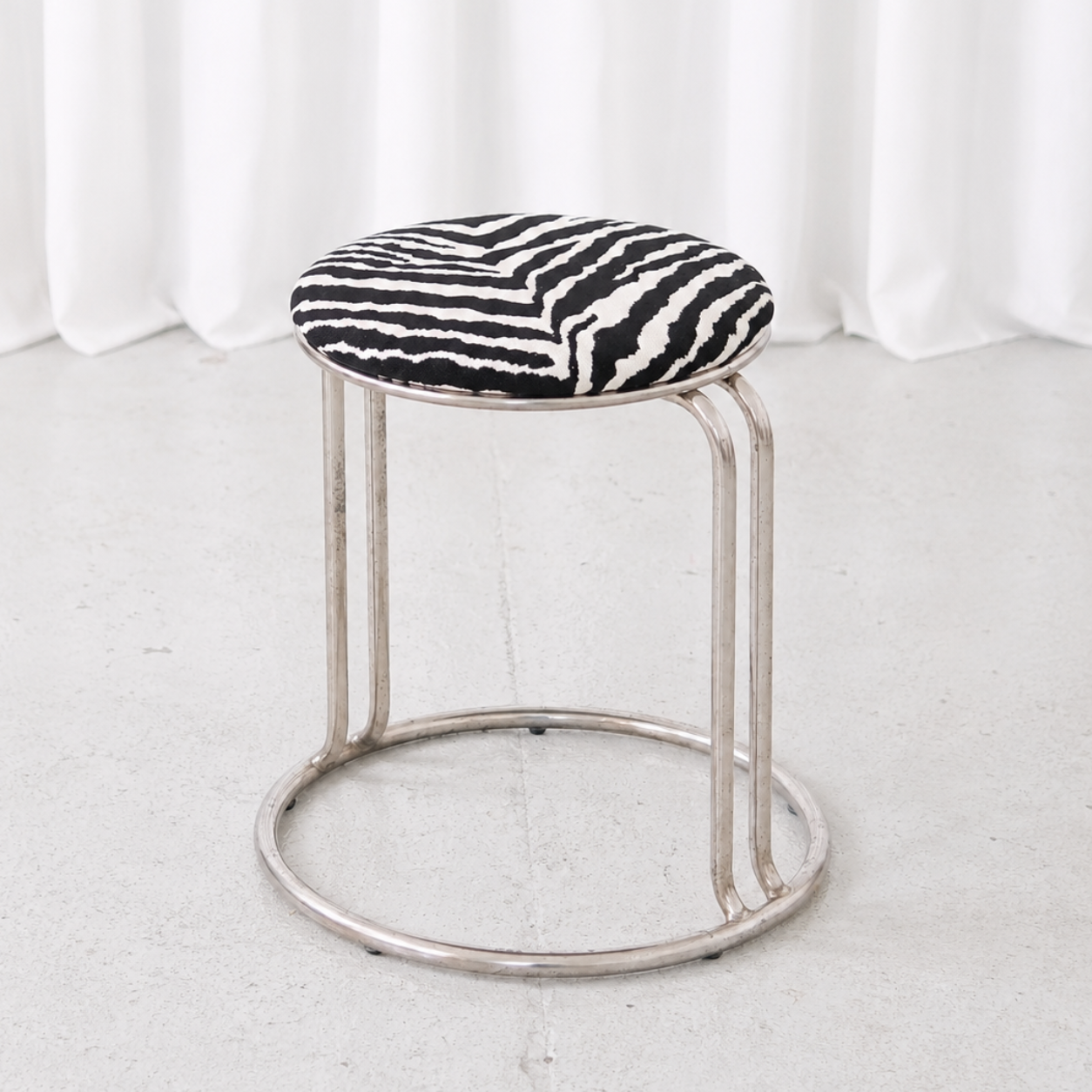 Vintage chrome stool with round zebra upholstered seat and sculptural tubular metal frame. A distinctive accent piece in good vintage condition.