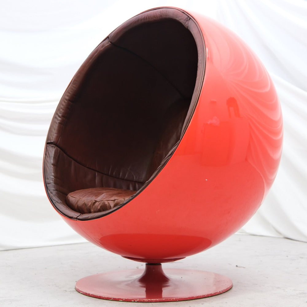 Original vintage Eero Aarnio Ball Chair with red fiberglass shell and brown leather interior. Iconic Finnish design from Helsinki. Worldwide shipping available.