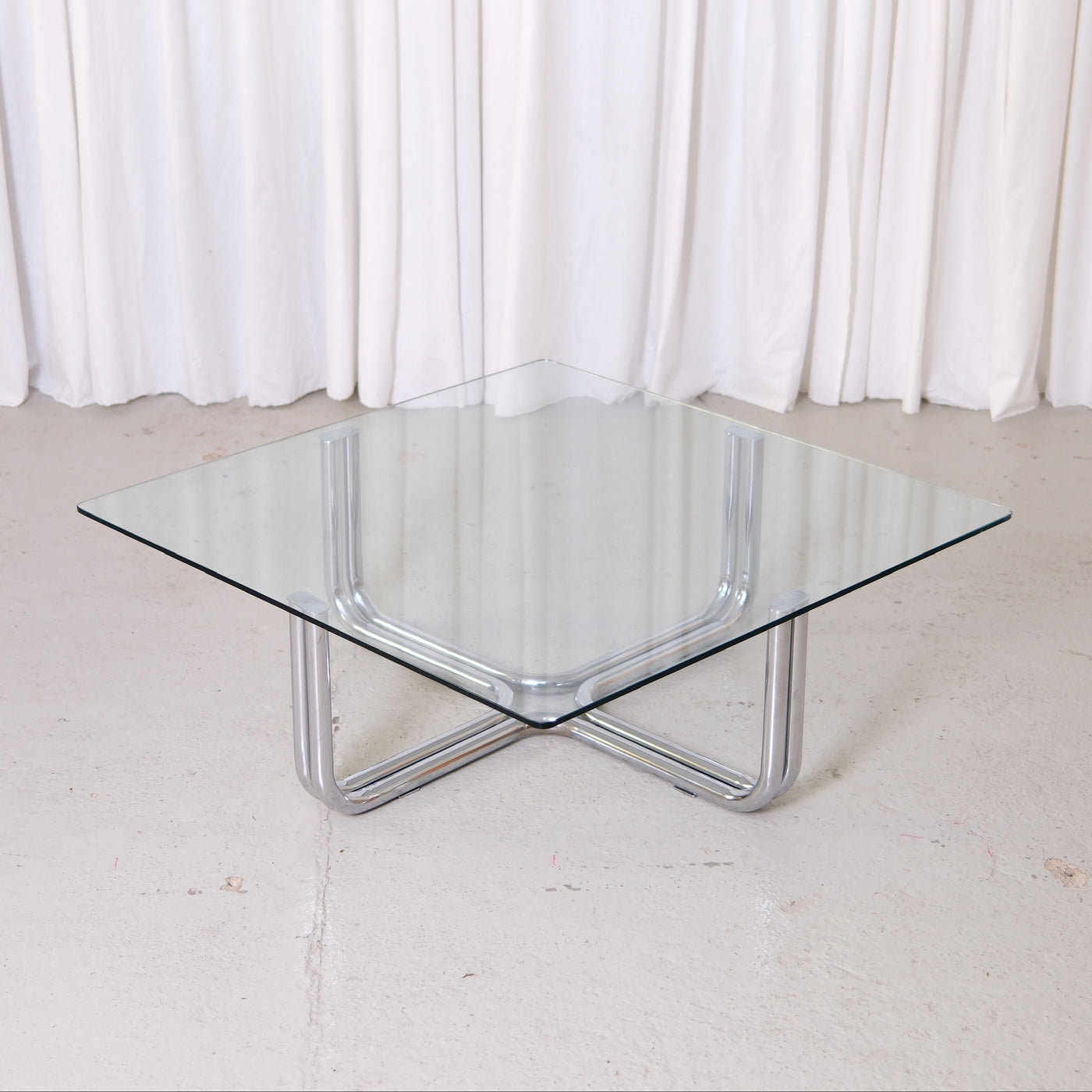 Vintage Italian glass coffee table with square 110 x 110 cm top and chrome tubular steel base. Good vintage condition with minor glass wear.
