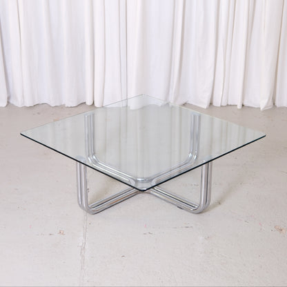 Vintage Italian glass coffee table with square 110 x 110 cm top and chrome tubular steel base. Good vintage condition with minor glass wear.