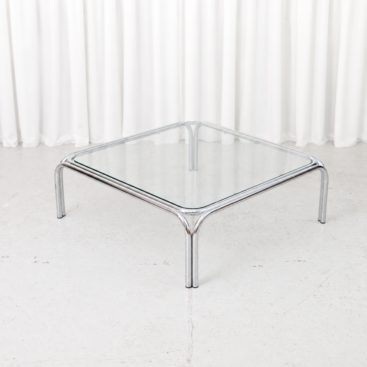 Vintage Italian coffee table with a polished tubular chrome frame and square glass top.