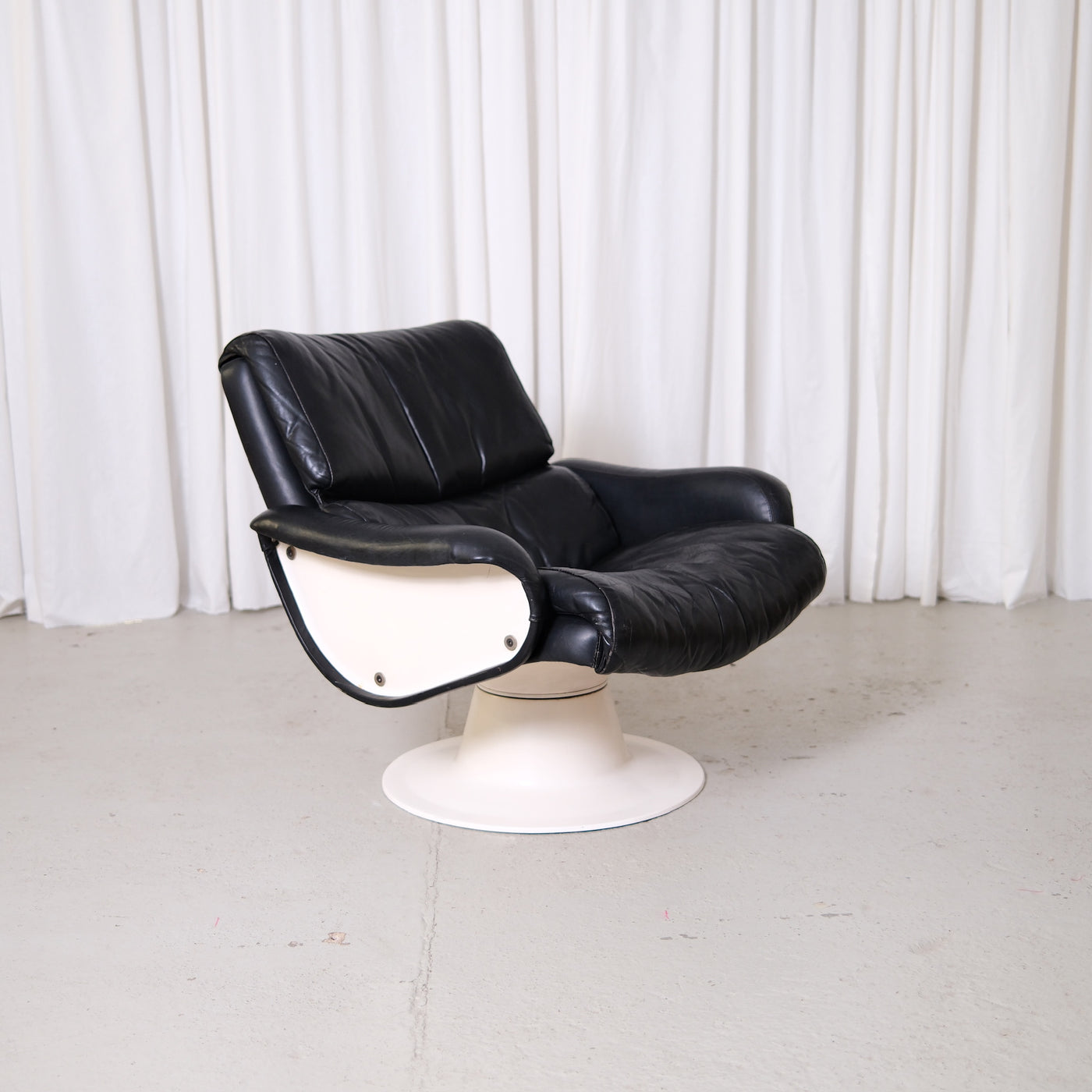Vintage Yrjö Kukkapuro Saturnus lounge chair in black leather with white swivel base. Finnish postmodern design classic with original patina and rotating base.