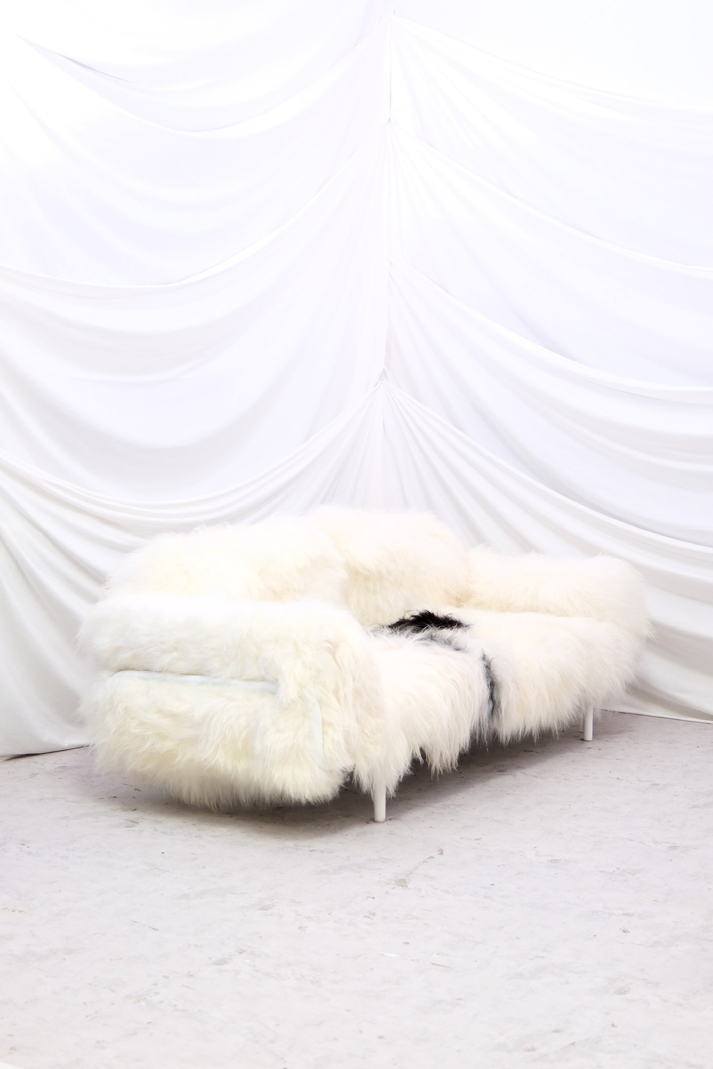 Rare 1970s sheepskin sofa with sculptural long wool finish and light legs. A soft, showstopping statement piece. Unused.