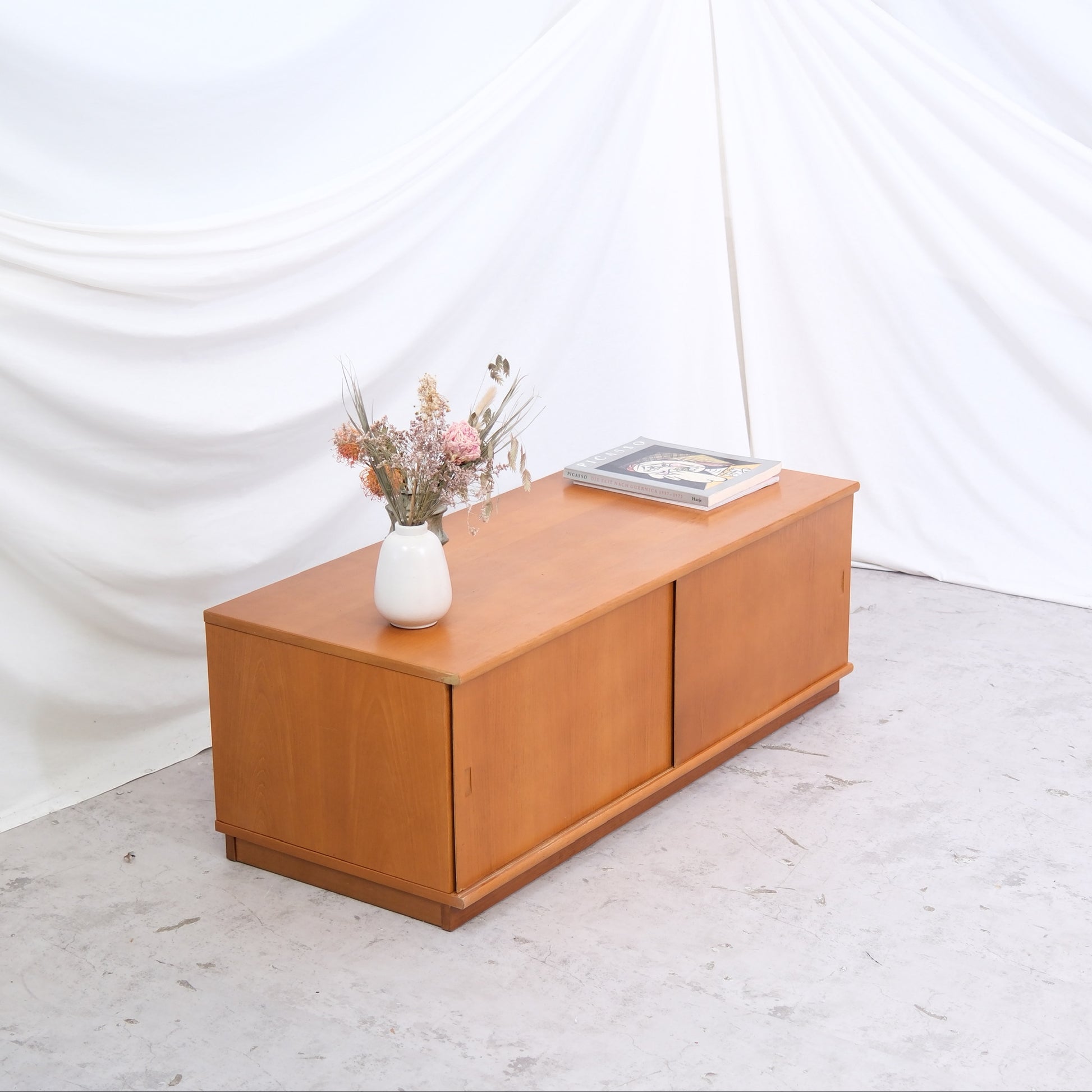 Vintage teak sideboard with sliding doors and warm teak tone. 120 cm wide and ideal as a media console or low storage. Helsinki pickup and worldwide shipping available.