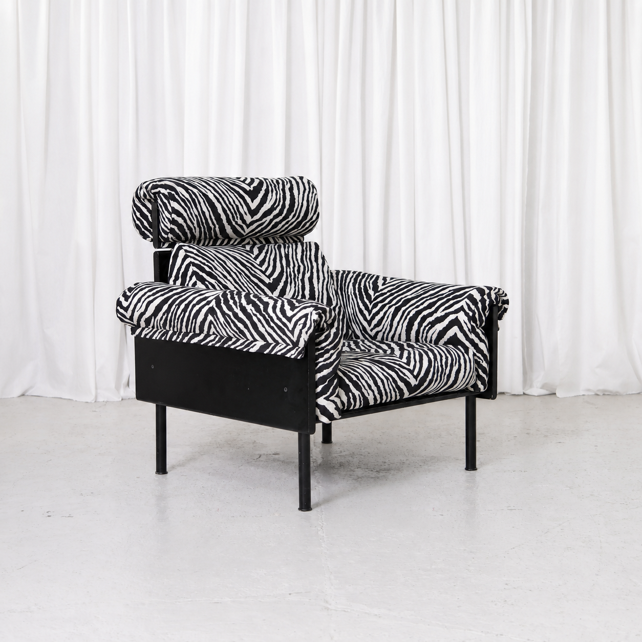 Yrjö Kukkapuro Ateljee armchair with black frame, zebra upholstery and matching headrest. Iconic Finnish modernist design in good vintage condition.