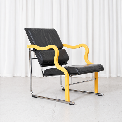 Vintage Yrjö Kukkapuro Experiment lounge chair for Avarte with black leather upholstery, chrome frame and sculptural yellow armrests.