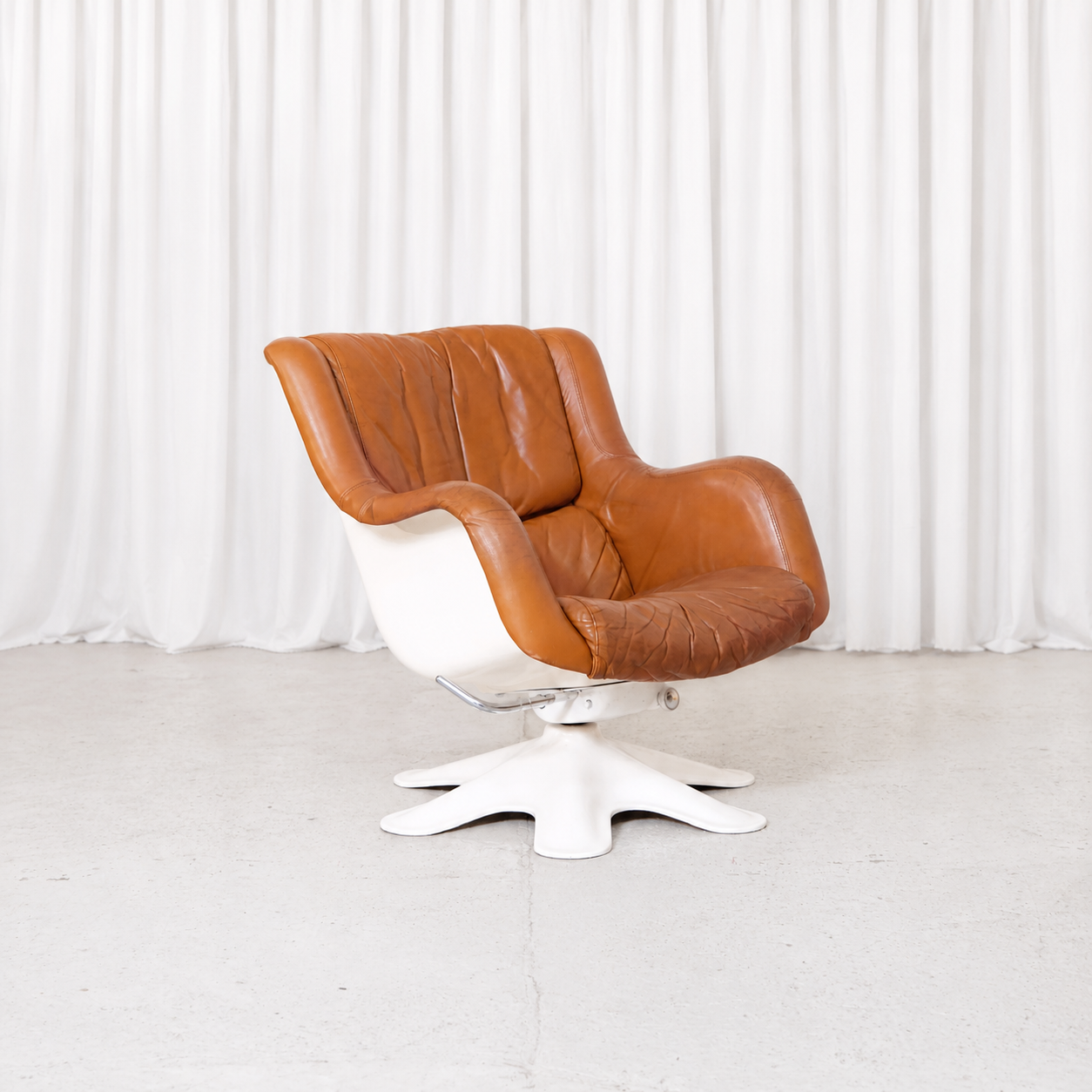 Vintage Yrjö Kukkapuro Karuselli 418 “Little Karuselli” for Haimi with brown leather upholstery, white fibreglass shell and swivel base.