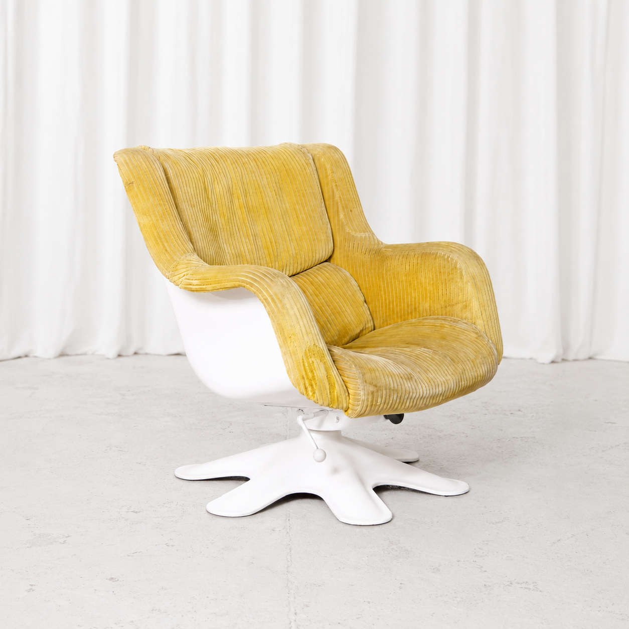 Yrjö Kukkapuro Model 418 armchair with yellow corduroy upholstery, sculptural white shell and swivel pedestal base. Original vintage character with visible wear.