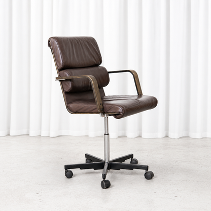 Vintage Plaano office chair designed by Yrjö Kukkapuro with brown leather upholstery, wooden armrests and a swivel base with castors.