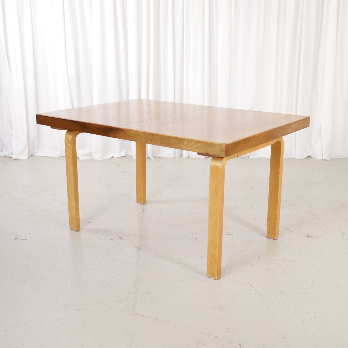 Alvar Aalto extendable teak table with figured birch legs — full table view