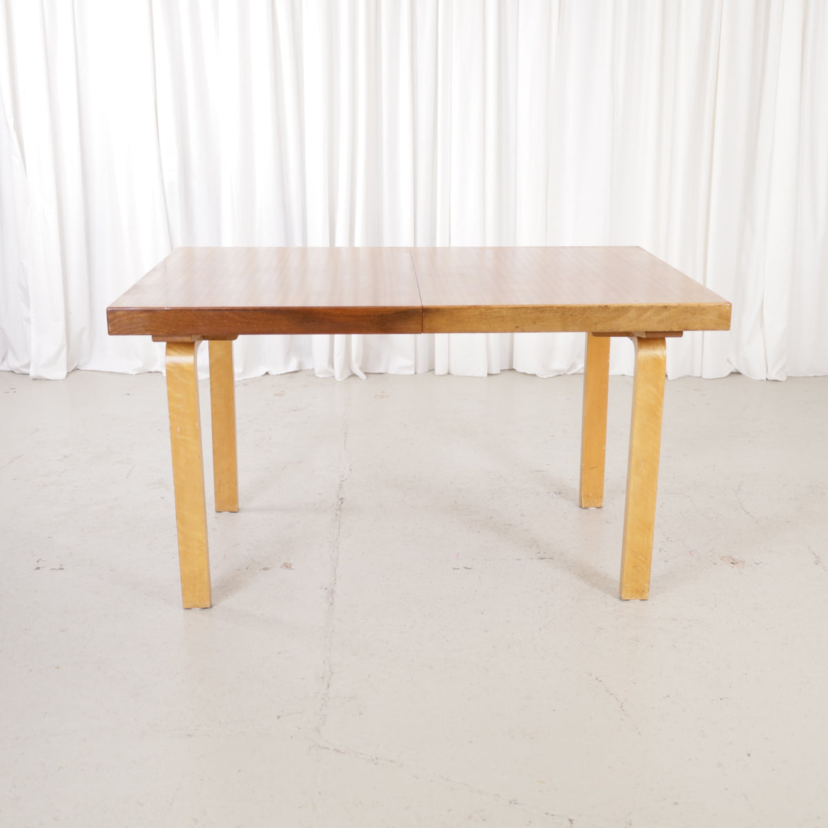 Alvar Aalto extendable teak table with figured birch legs — full table view