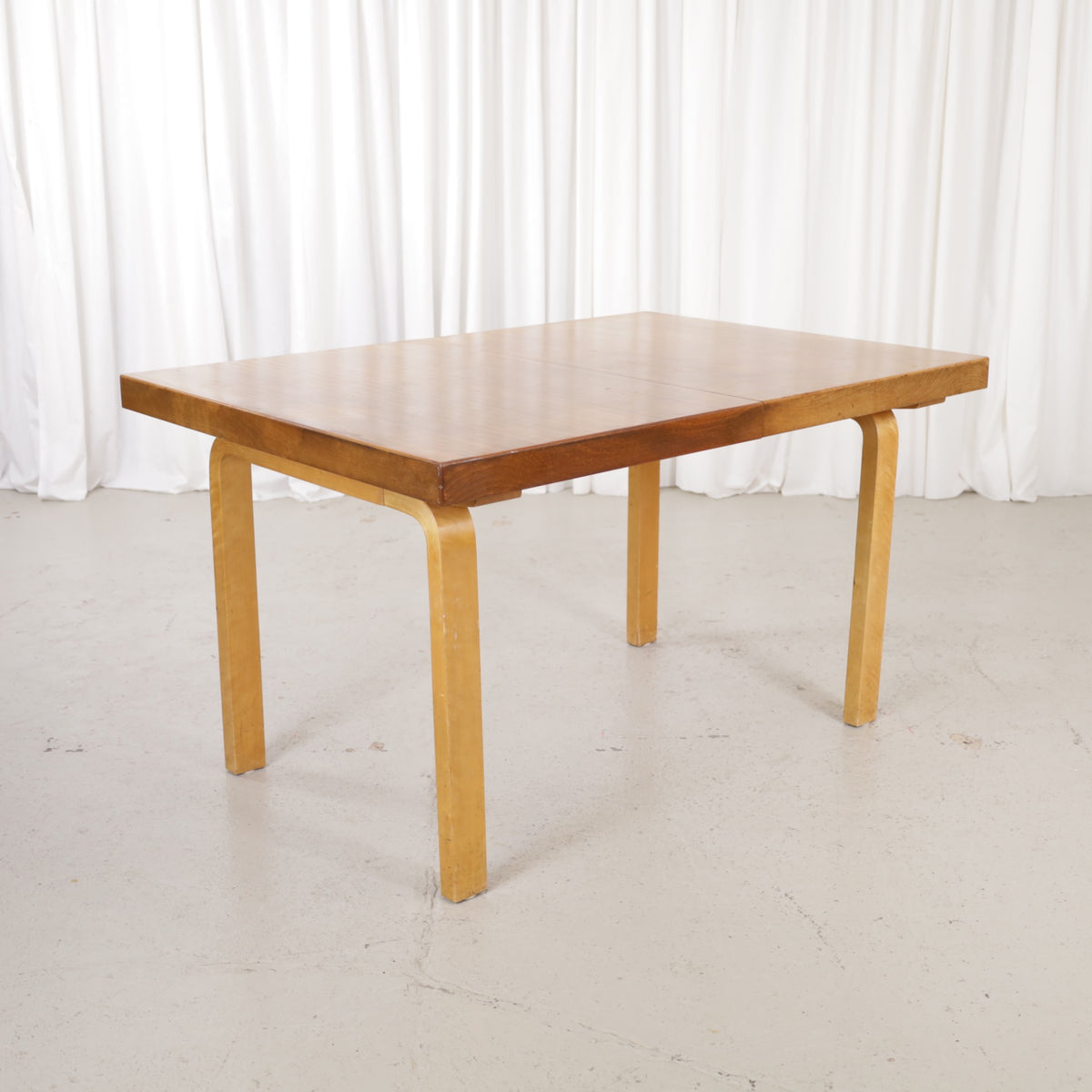 Alvar Aalto extendable teak table with figured birch legs — full table view