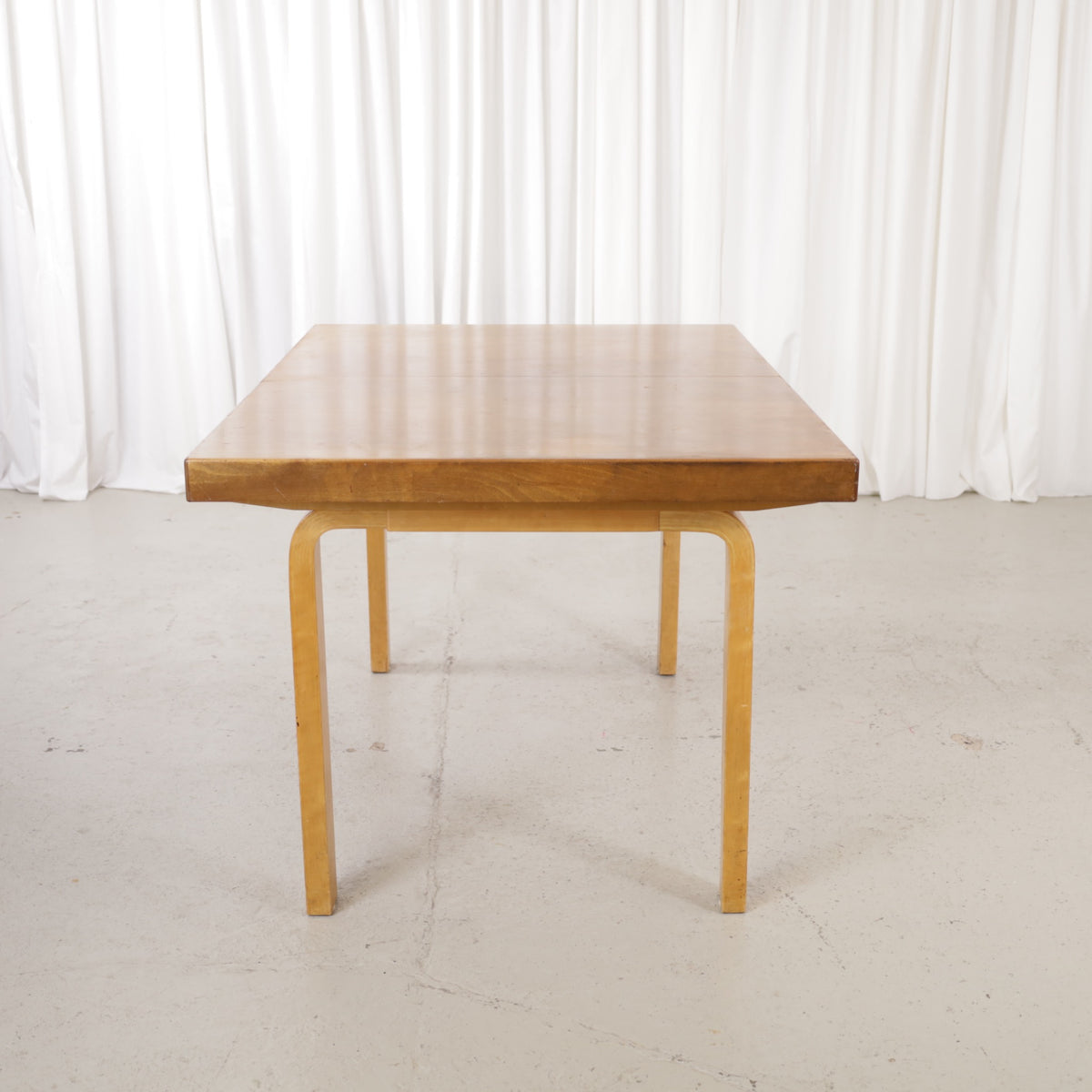 Alvar Aalto extendable teak table with figured birch legs — full table view