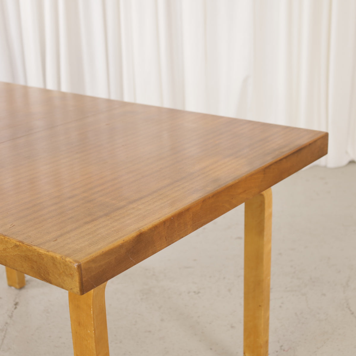 Alvar Aalto extendable teak table with figured birch legs — tabletop, extension leaf or frame detail