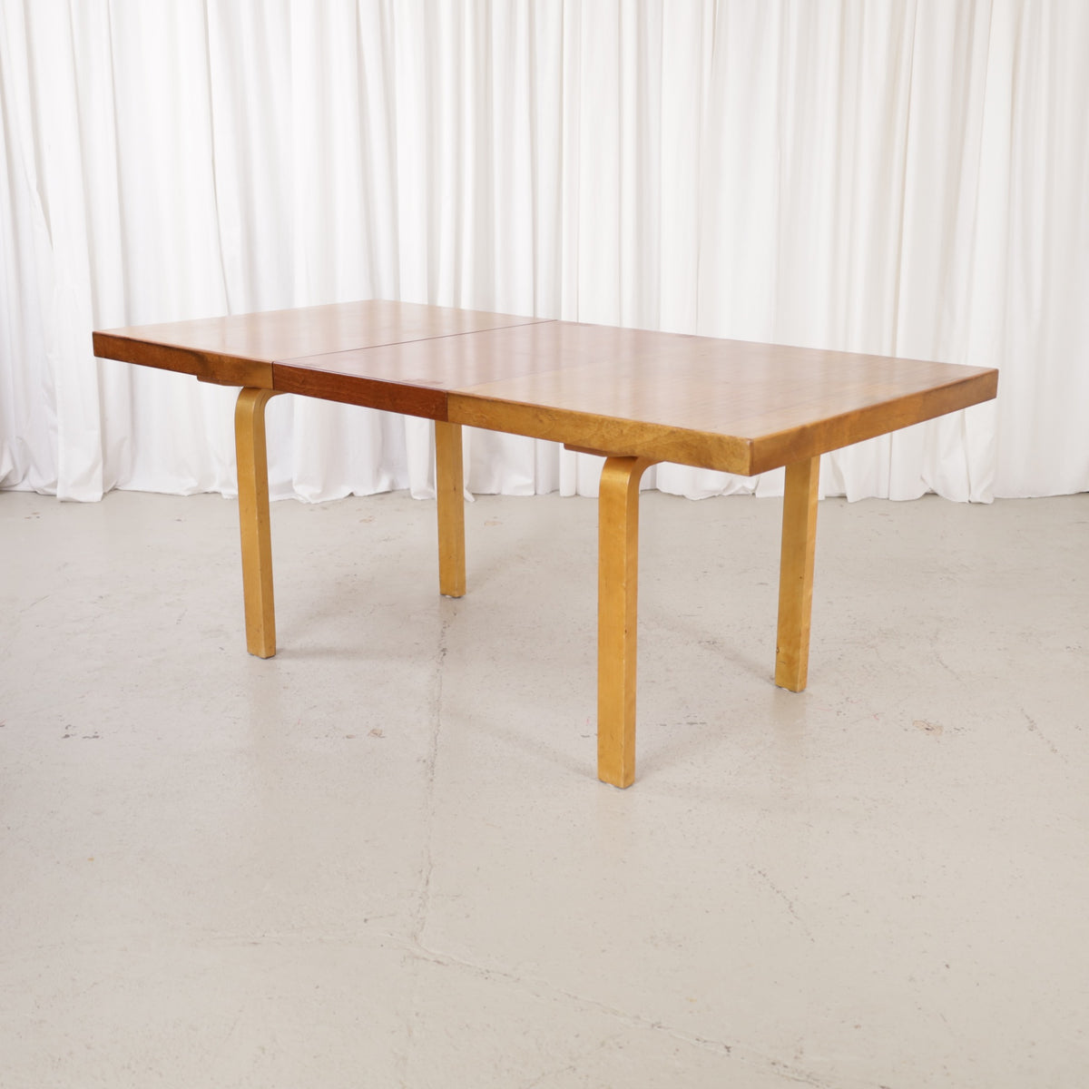 Alvar Aalto extendable teak table with figured birch legs — full table view