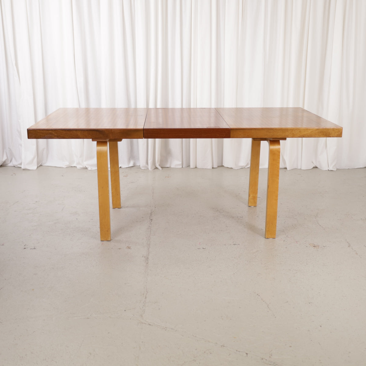 Alvar Aalto extendable teak table with figured birch legs — full table view