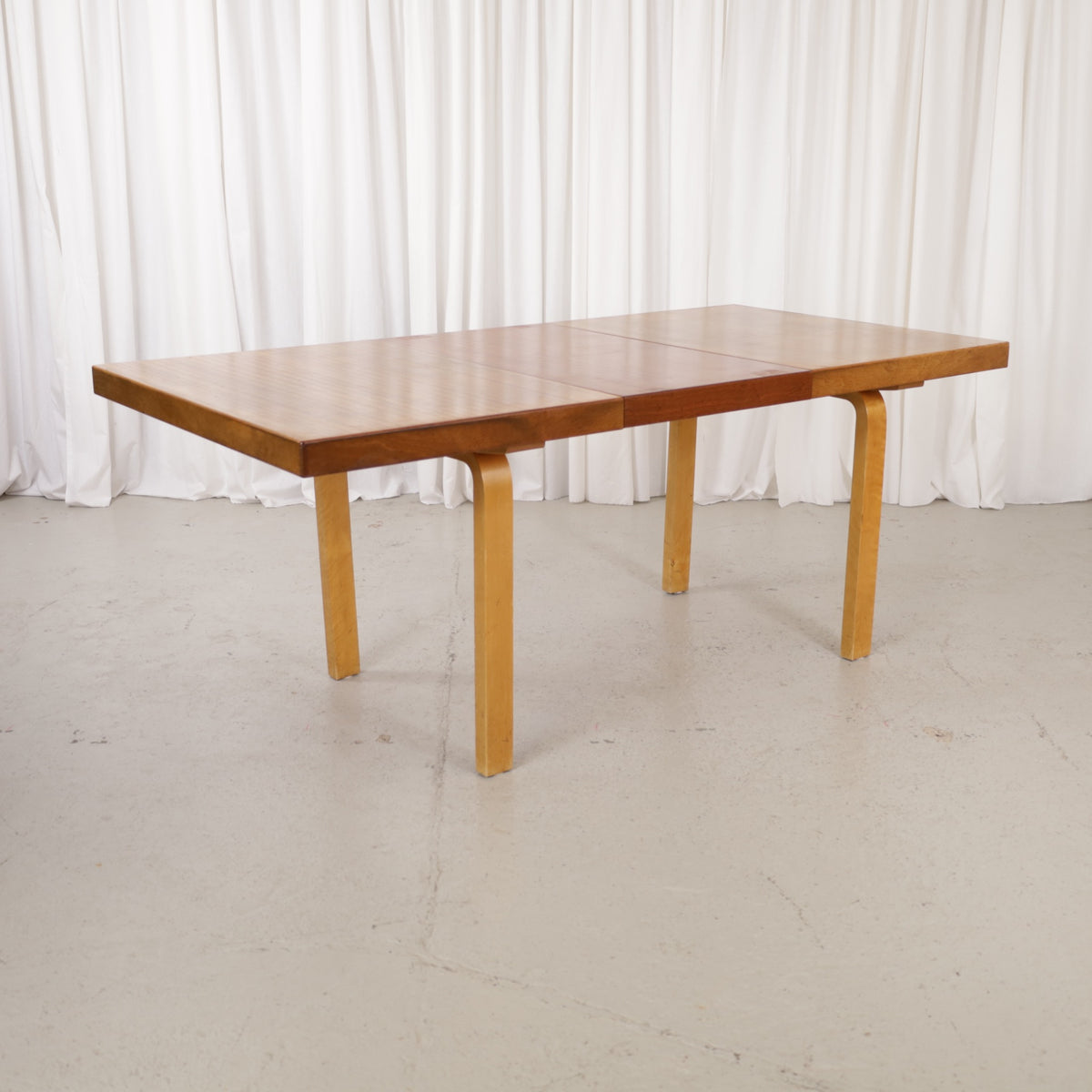 Alvar Aalto extendable teak table with figured birch legs — full table view