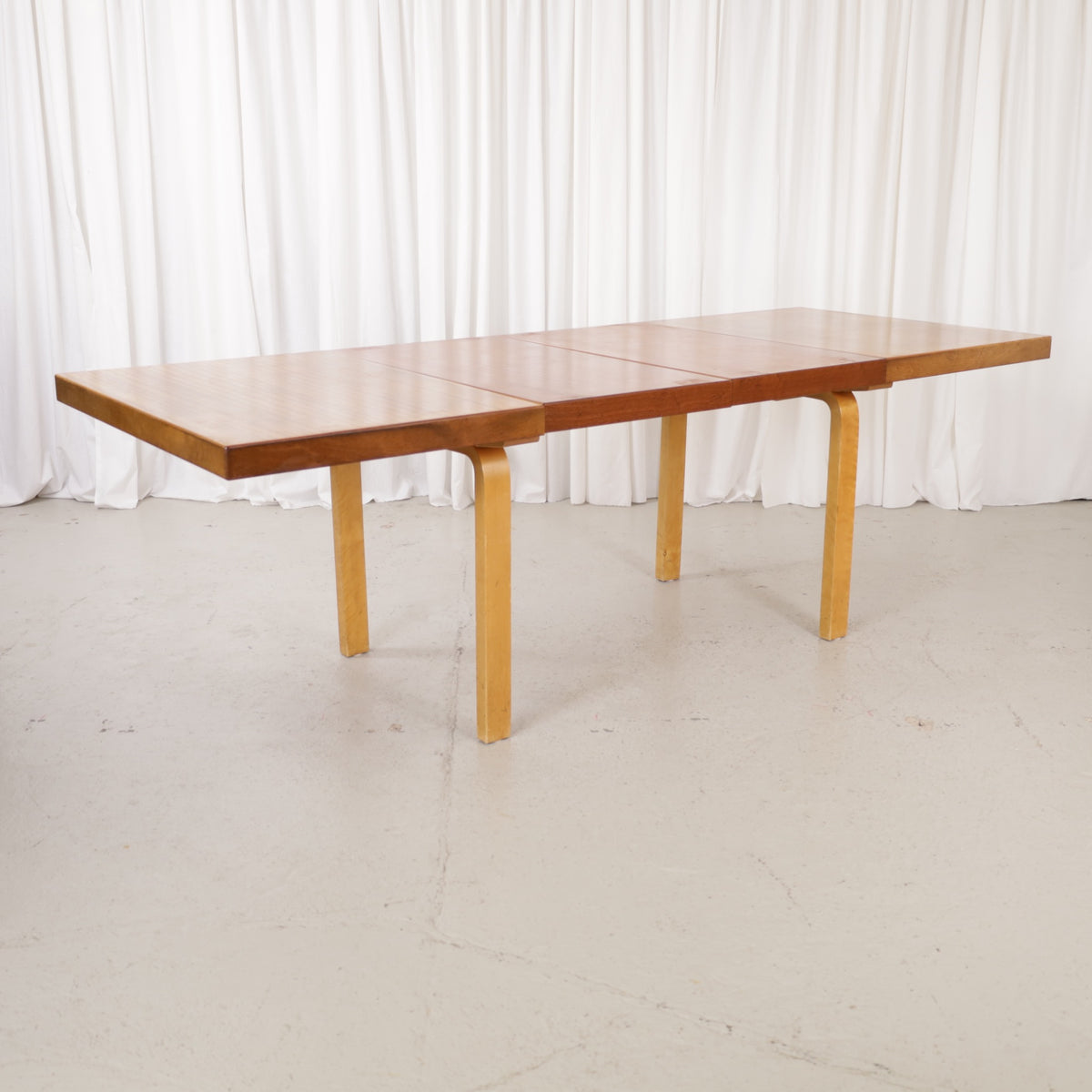 Alvar Aalto extendable teak table with figured birch legs — full table view