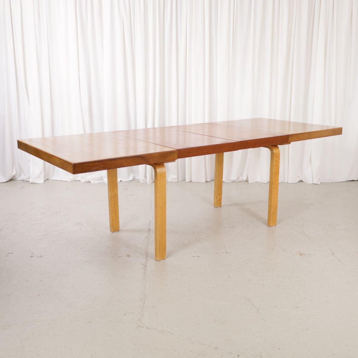 Alvar Aalto extendable teak table with figured birch legs — full table view