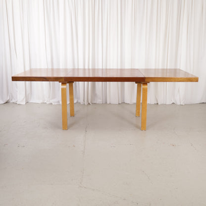 Alvar Aalto extendable teak table with figured birch legs — full table view