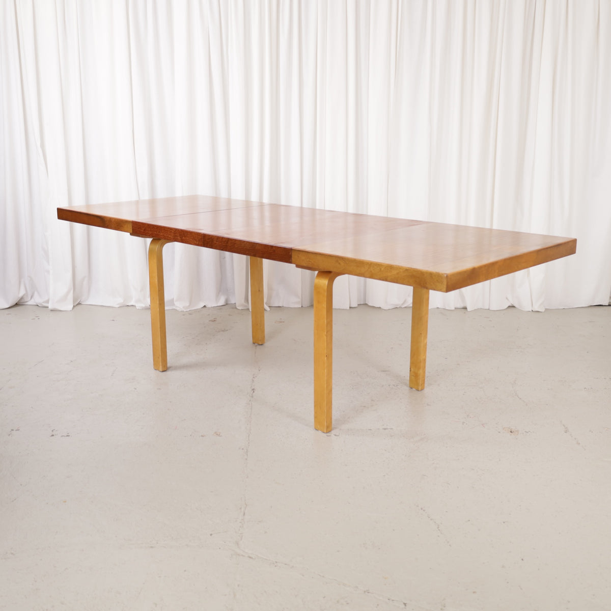 Alvar Aalto extendable teak table with figured birch legs — full table view