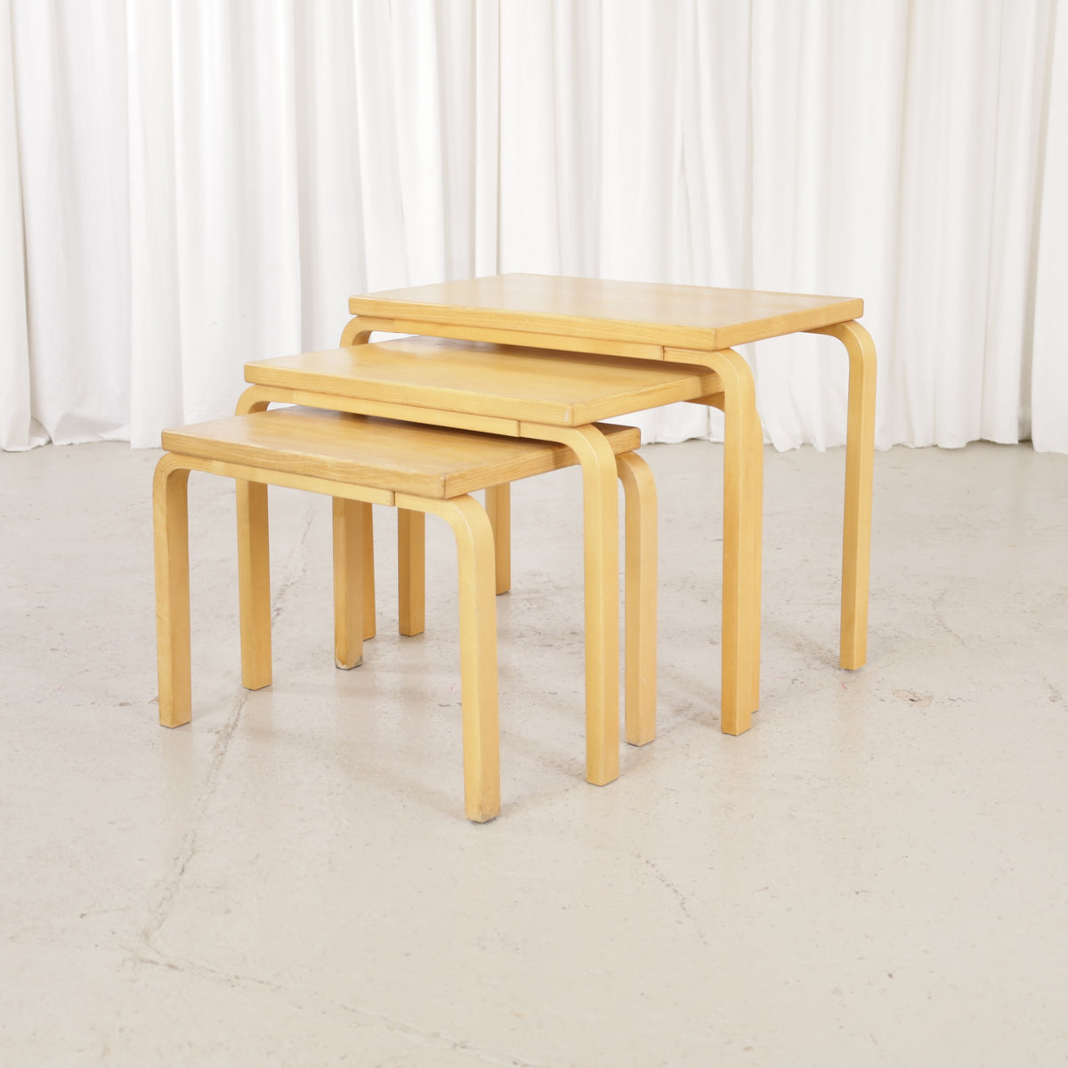Alvar Aalto nesting tables for Artek, patinated wooden surfaces and bent legs
