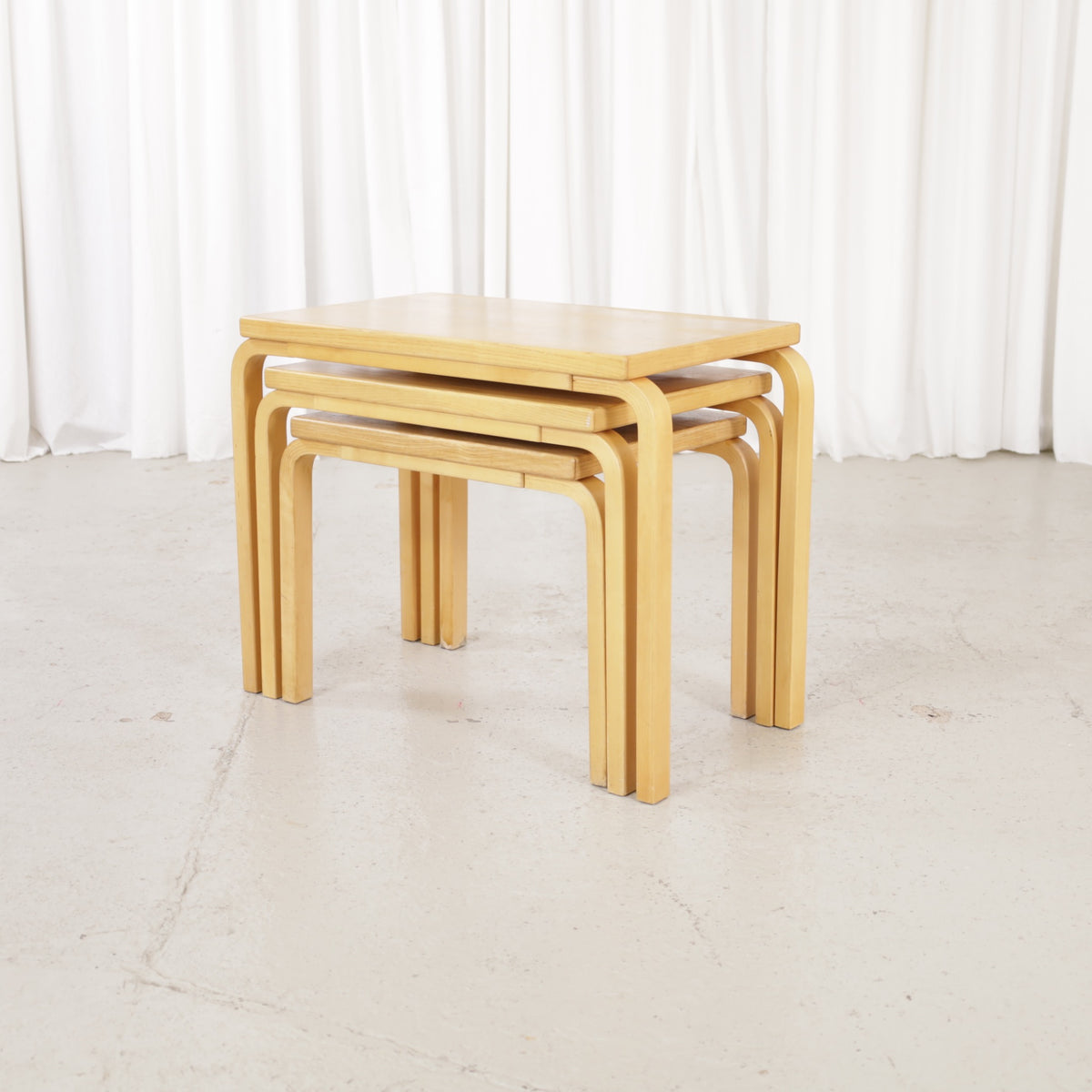 Alvar Aalto nesting tables for Artek, patinated wooden surfaces and bent legs