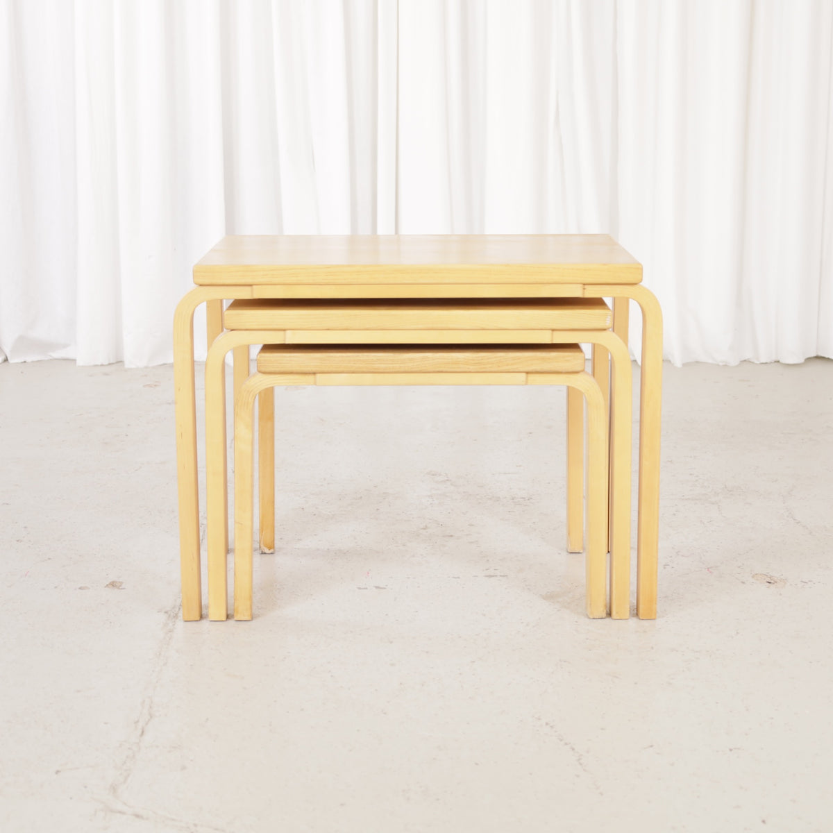 Alvar Aalto nesting tables for Artek, patinated wooden surfaces and bent legs