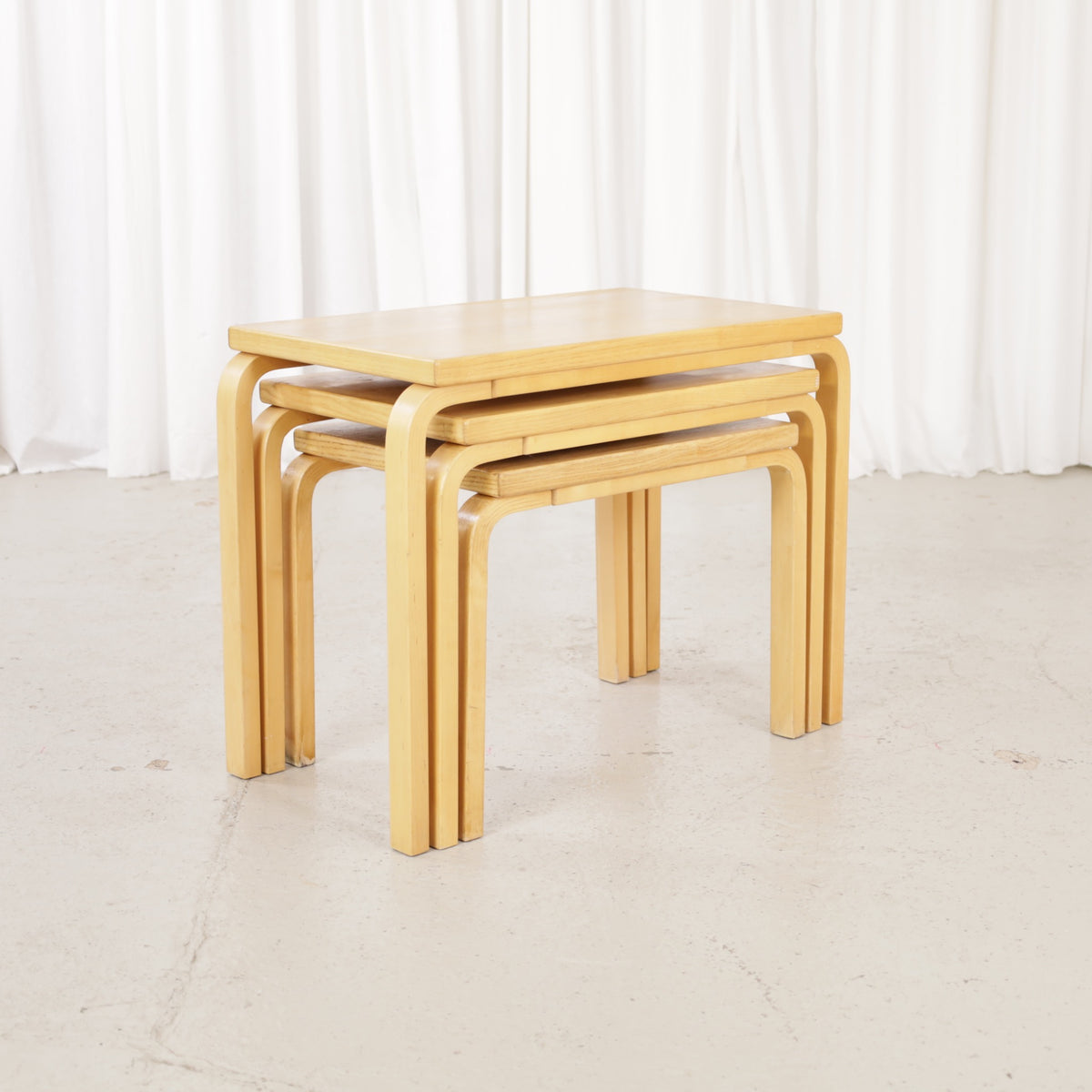 Alvar Aalto nesting tables for Artek, patinated wooden surfaces and bent legs