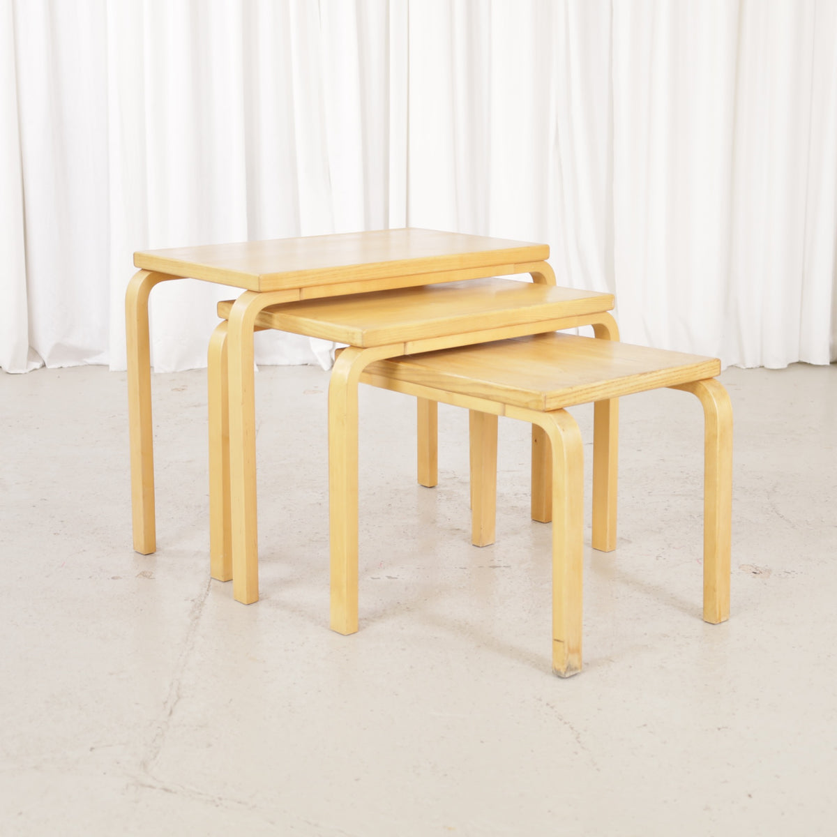 Alvar Aalto nesting tables for Artek, patinated wooden surfaces and bent legs